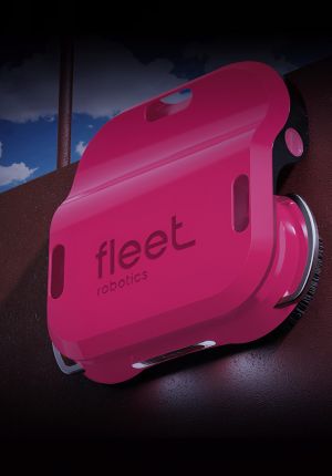 3D render of a bright pink Fleet Robotics hull-cleaning robot with brushes, attached to the dark red side of a ship's hull.